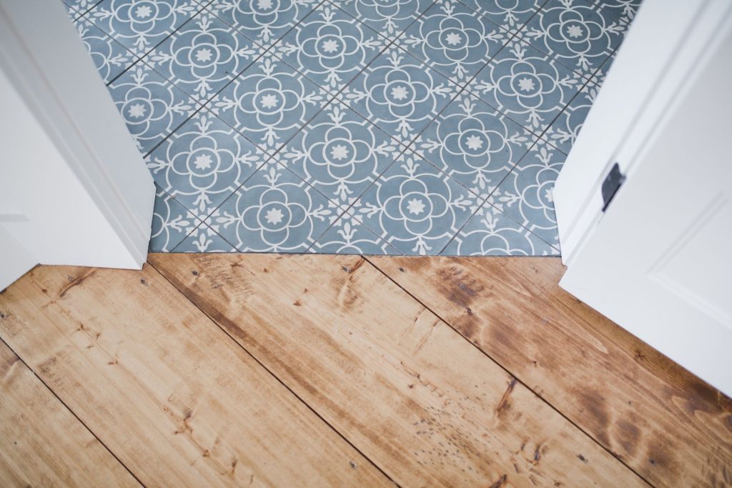 Vieux parquet massif usé à côté de carreaux de ciment